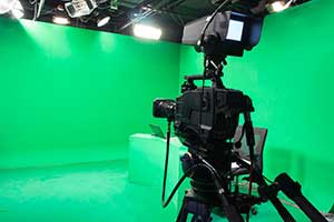 Camera facing green screen during film production