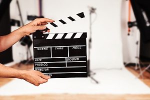 man holding film clapper while he is directing a movie that is covered under on set liability and production insurance