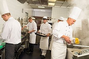 chefs cooking in the kitchen of a professional Los Angeles, CA restaurant that is covered by equipment breakdown insurance since the kitchen equipment is used every day