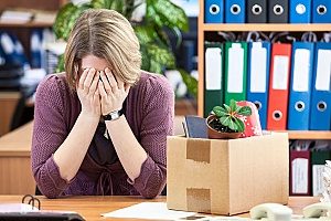 woman at her office who believes to have been wrongfully terminated but her company is equipped with business insurance