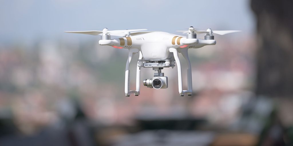 large drone flying over a city that is equipped with aviation liability insurance in order to protect the company operating the drone in case it were to crash