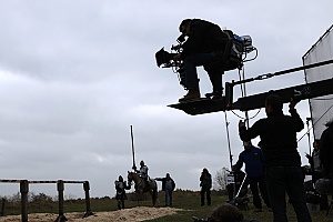 a film producer standing on a platform that is provided by the film company which has production insurance in case the cast or crew were to become injured on set