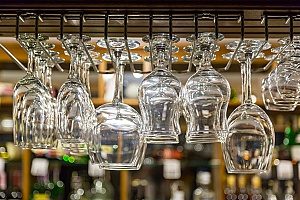 glasses lined up at a bar that plans on contacting an entertainment insurance broker for general protection of their bar