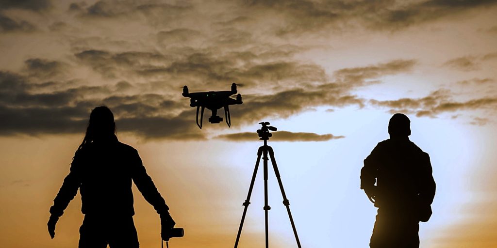 silhouettes of a film crew operating a drone that is covered with aviation liability insurance and other lines of drone insurance