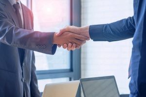 a cannabis insurance broker shaking hands with a medical marijuana dispensary owner to discuss how product liability insurance can significantly benefit the dispensary