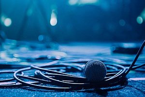a microphone backstage with a ton of wiring equipment surrounding it