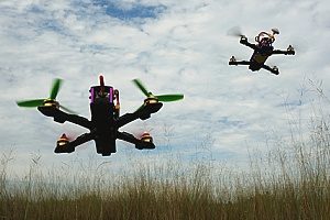 two drones covered under a drone insurance policy that are racing each other during an event
