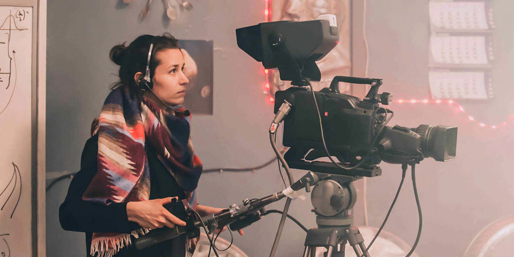 a camera woman using a camera for a film company that has production insurance