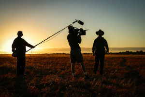 Camera crew filming in the grasslands for insured film production