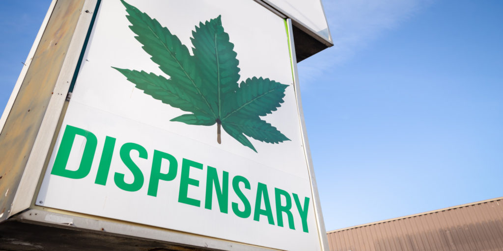 Marijuana dispensary sign with green leaf on it