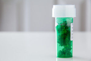Medicinal cannabis in a green prescription bottle