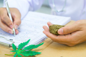 a female doctor prescribing medical marijuana while holding some in her hand