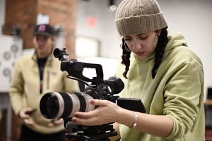 woman using a camera with filmmakers protection against liabilities
