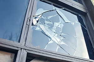 broken glass in the window of a home that is covered by insurance