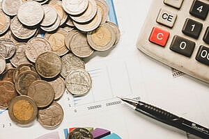 coins and a calculator representing the cost of D&O insurance