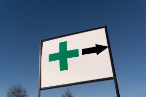 medical marijuana retailer sign with arrow pointing towards a dispensary protected with Maine cannabis insurance
