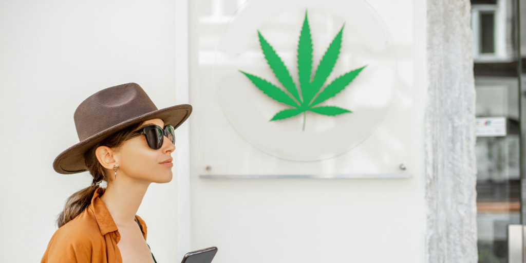 woman walking by a cannabis store covered with E&O insurance coverage