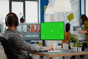 videographer using computer with chroma key mock up isolated display