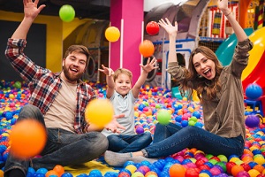 cheerful little child have fun with his parents in entertainment