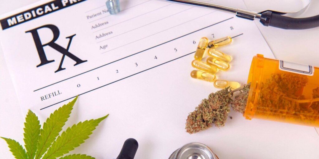 assorted cannabis products pills and cbd oil over medical prescription sheet