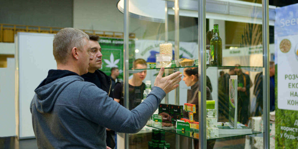 customer and sales manager standing in front of a counter with cannabis products and communicating