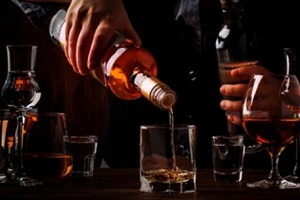 man pouring whiskey in glass