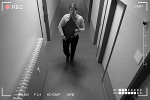 man stealing computer monitor walking in corridor scene through cctv camera