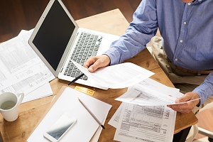 senior businessman reviewing statements and writing documents