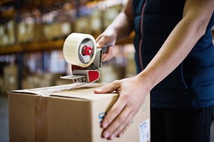 warehouse worker taping together a box