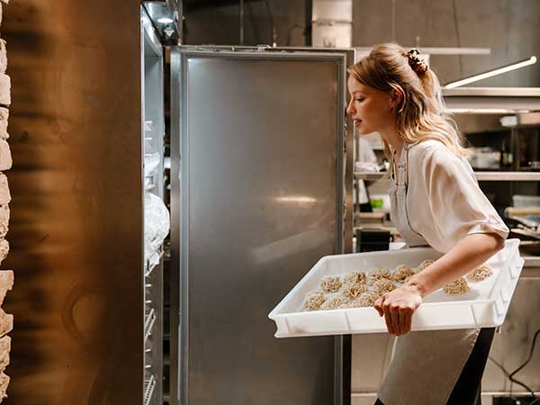 Chef putting dough in the fridge