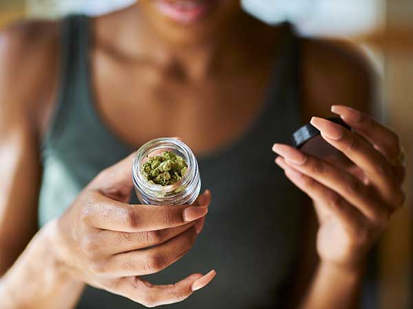 Woman looking at her cannabis container