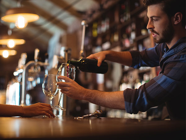 bar tender pouring glass of wine