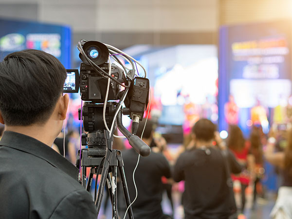 man filming a media event