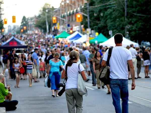 people walking along a local street festival