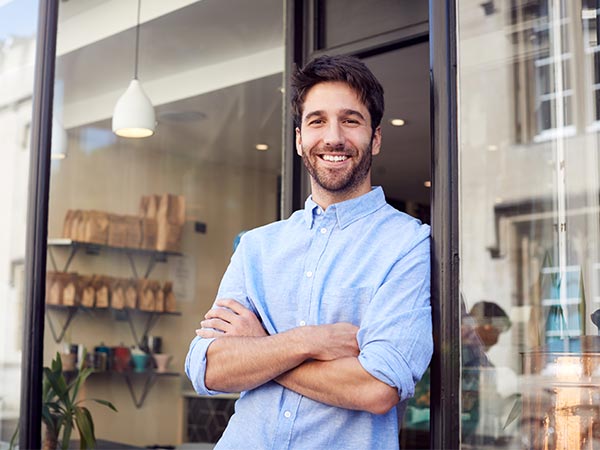 shop landlord standing with arms crossed in front of door