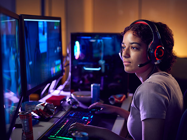young women with headset playing at an esports competition