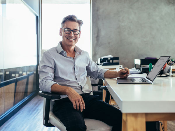 CEO sitting at his desk smiling