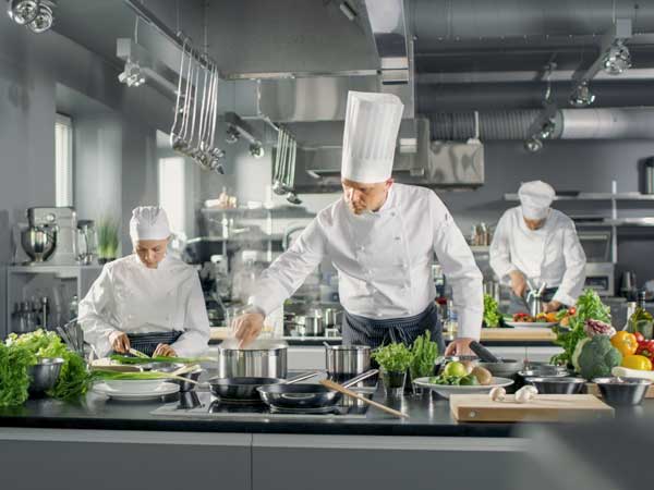 Chefs working in a hotel kitchen which has additional coverage from hospitality umbrella insurance