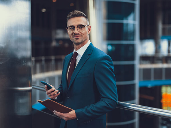 Financial executive smiling holding phone