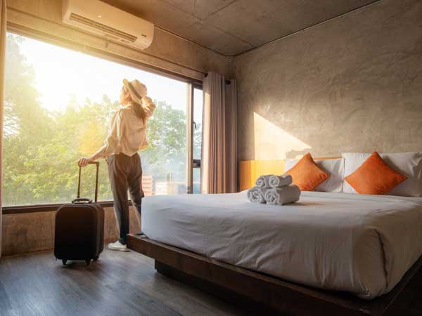 Hotel guest looking out the window of her room in the morning