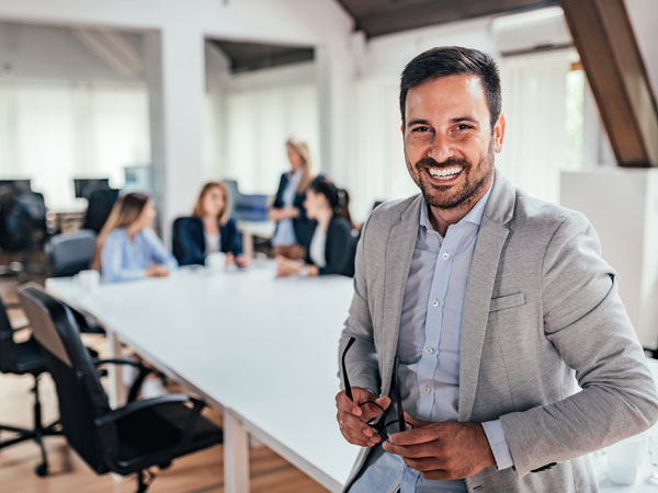 Man leaning on desk at work happy