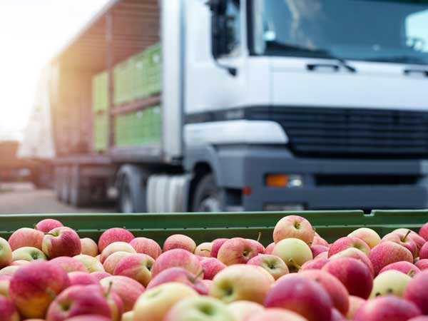 Restaurant food delivery truck behind crate of apples