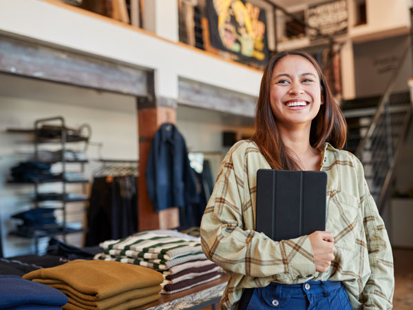 Woman in retail store smiling with iPad