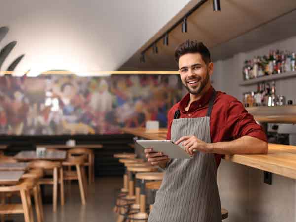 Restaurant owner standing with iPad