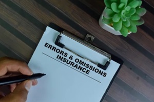 errors & omissions insurance write on a paperwork isolated on wooden table