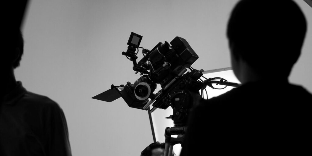 movie shooting or video filming production by crew team and professional equipment such as super ultra high definition digital camera with tripod and lighting set in studio and black and white