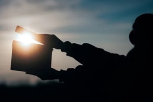 silhouette of hands holding a film slate in the sunset