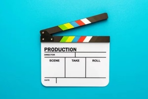 view photo of open white clapperboard over turquoise blue background