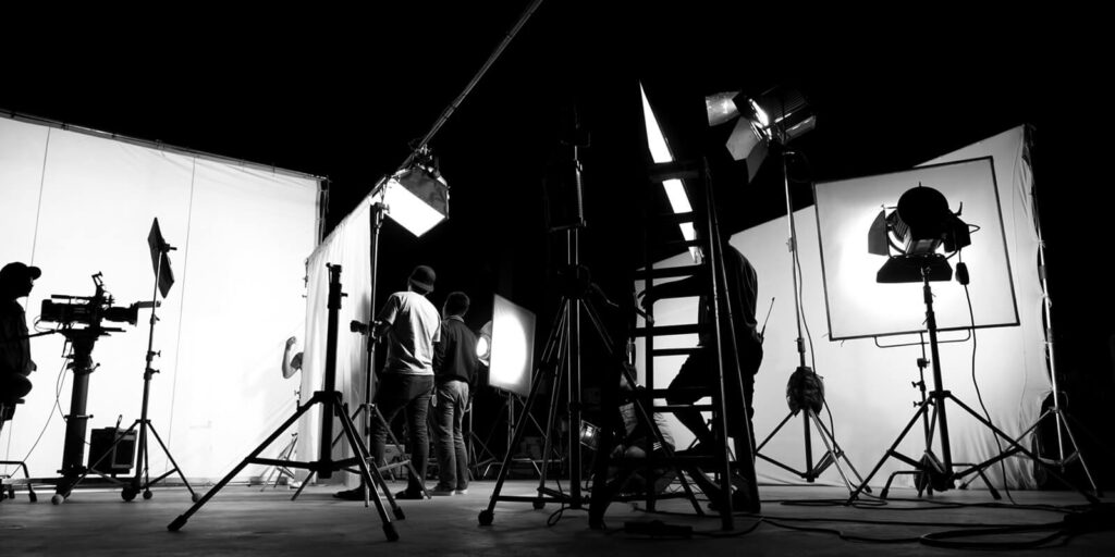 behind the scenes of TV commercial movie film or video shooting production which crew team and camera man setting up green screen for chroma key technique in big studio