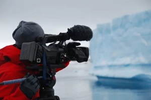 cameraman filming an iceberg in antarctica